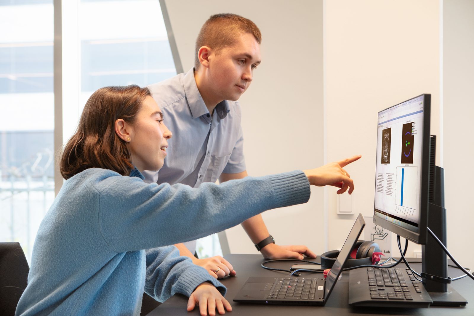 Two clinicians reviewing an ultrasound scan on a monitor