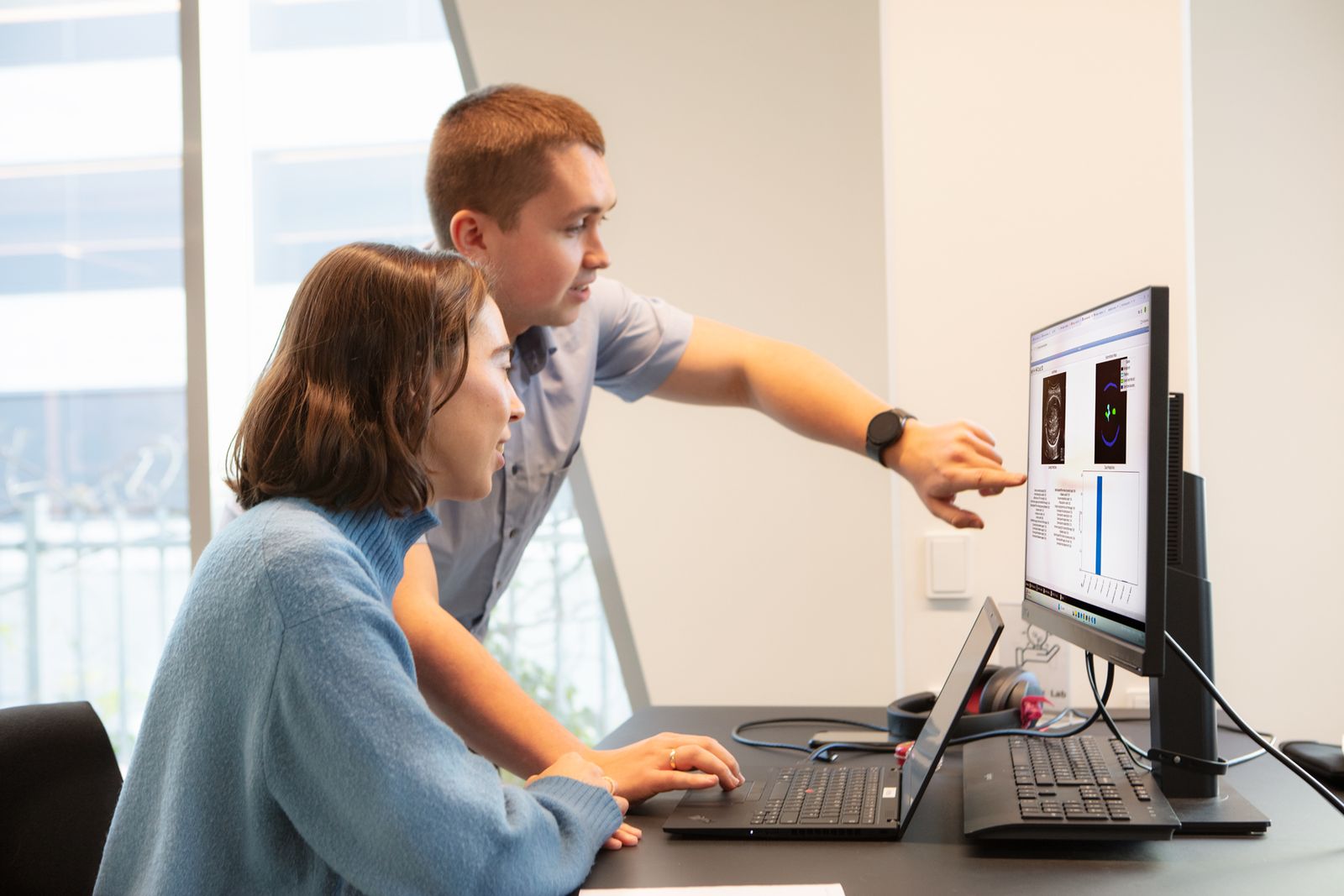 Two clinicians reviewing an ultrasound scan on a monitor
